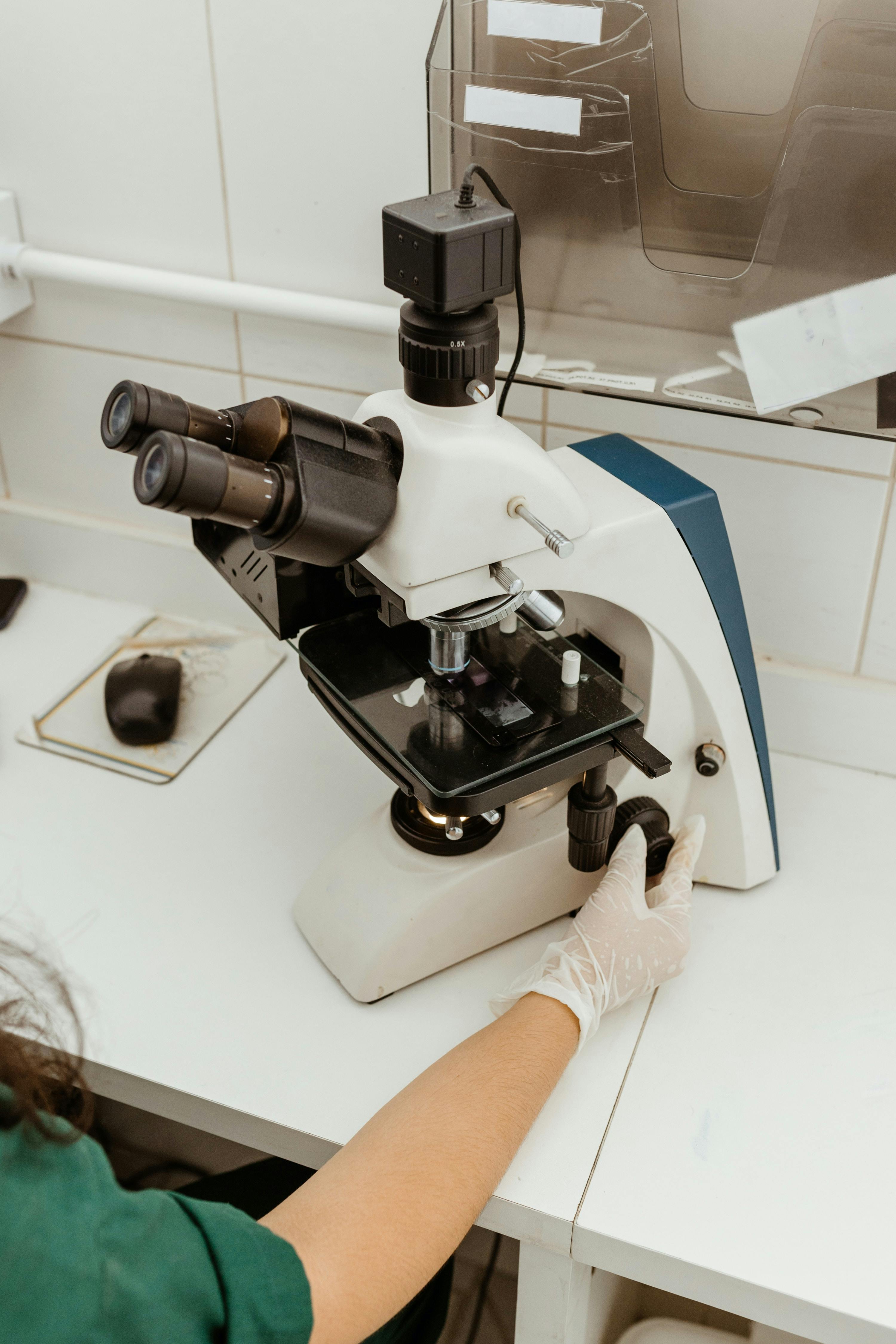 A healthcare professional examining a sample under a microscope