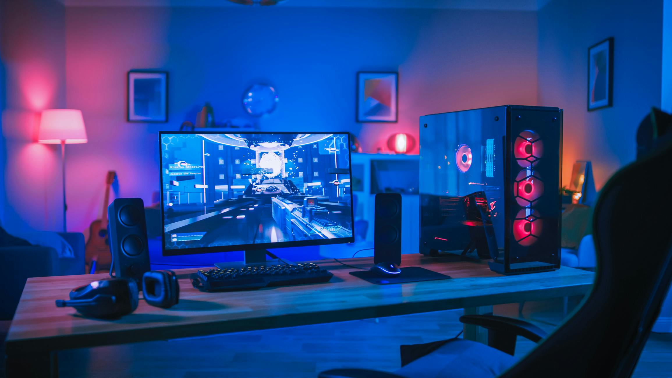 A gaming computer, monitor, speakers, and headphones on a desk