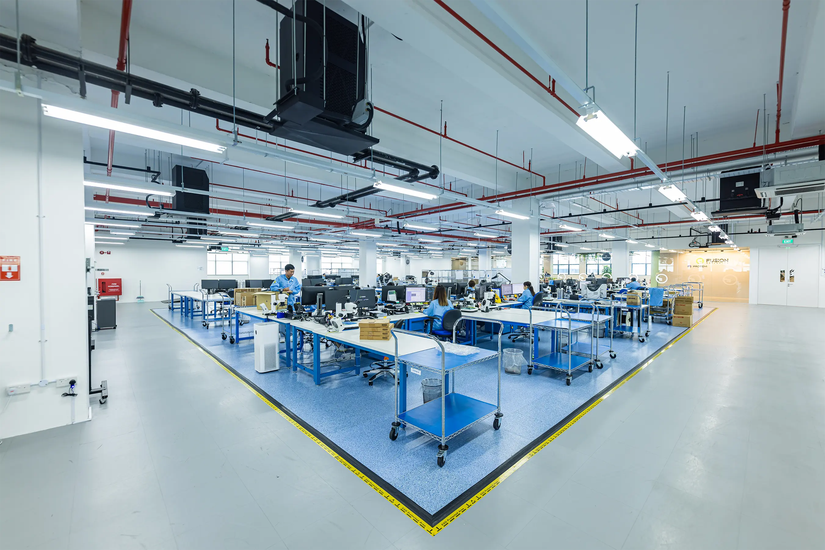 Quality inspectors sitting at their desks in a Fusion Worldwide Quality Testing Center
