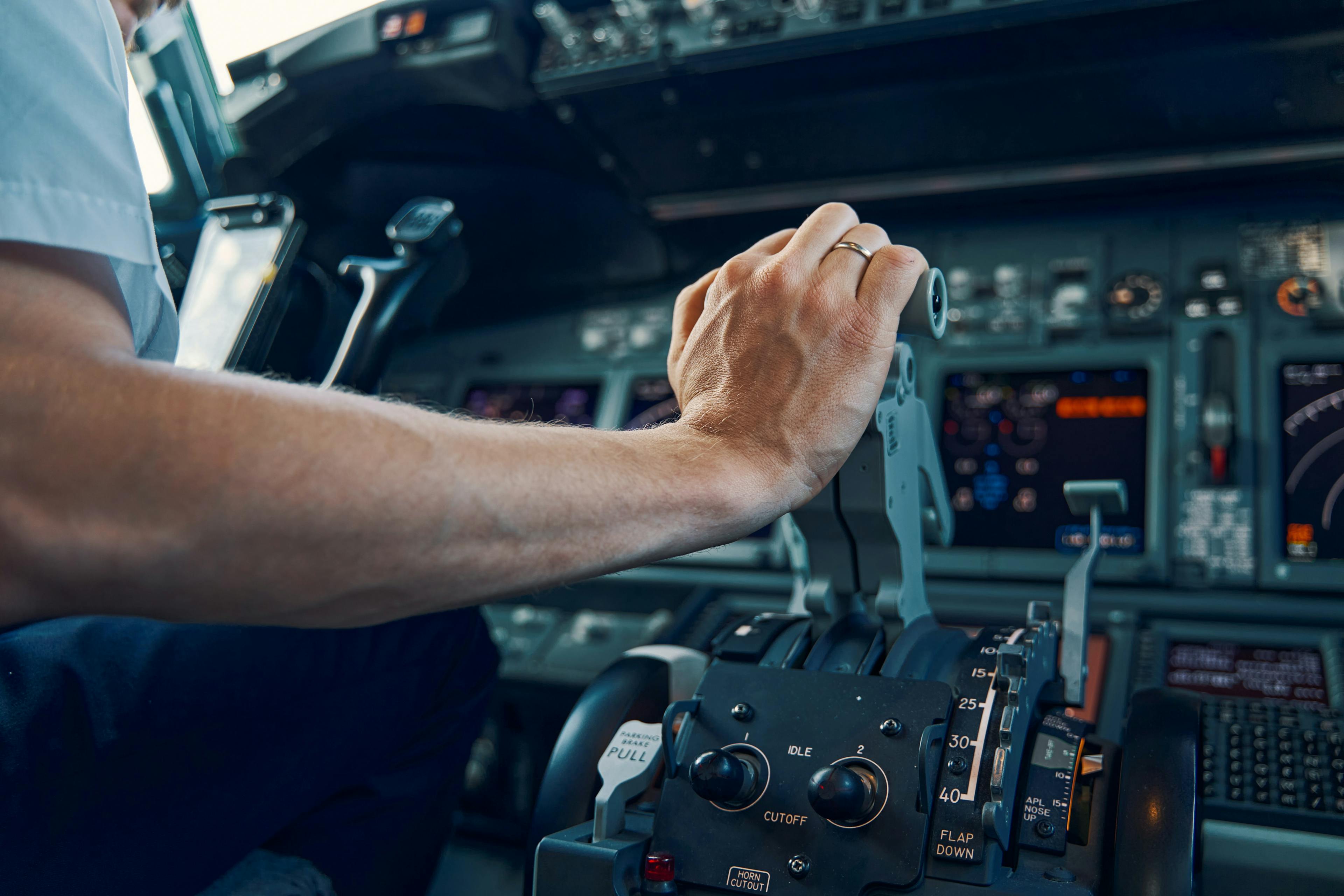 Pilot's hand engages the throttle in the cockpit of an airplane