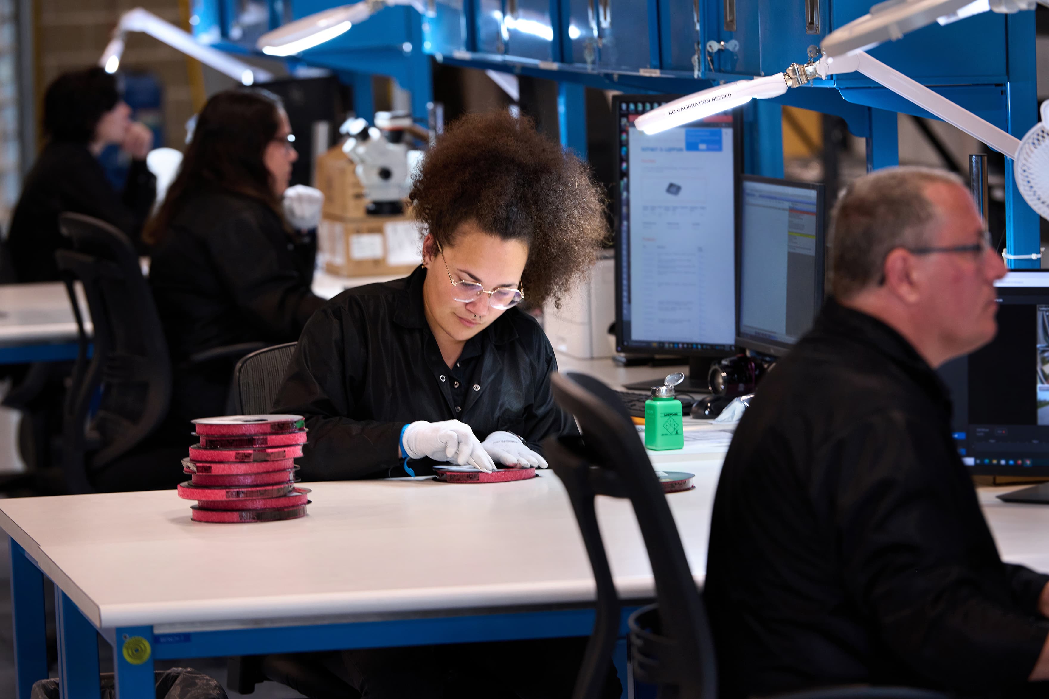 A quality process employee packaging electronic components at her workstation