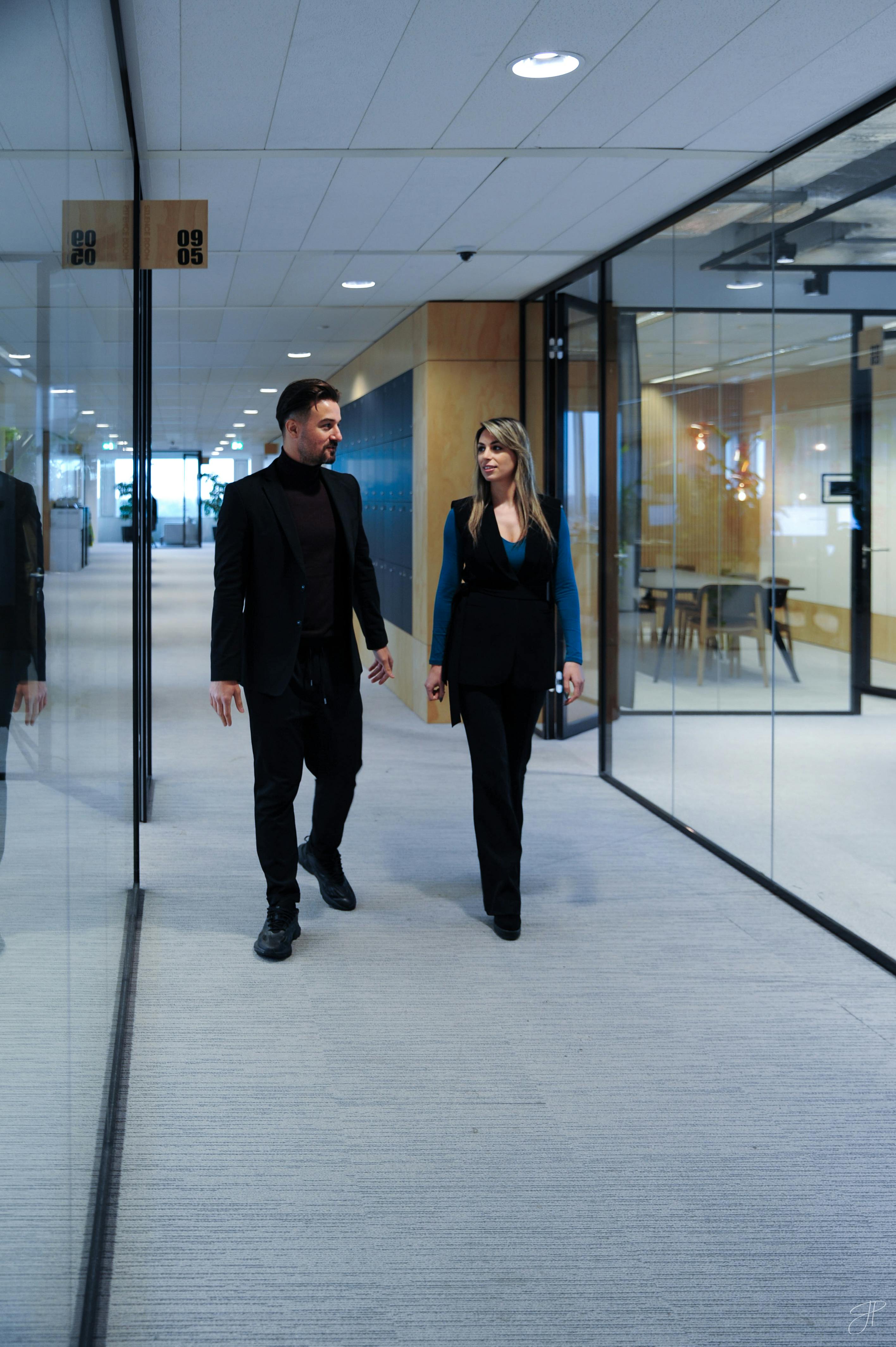 Two Fusion employees walking down an office hallway