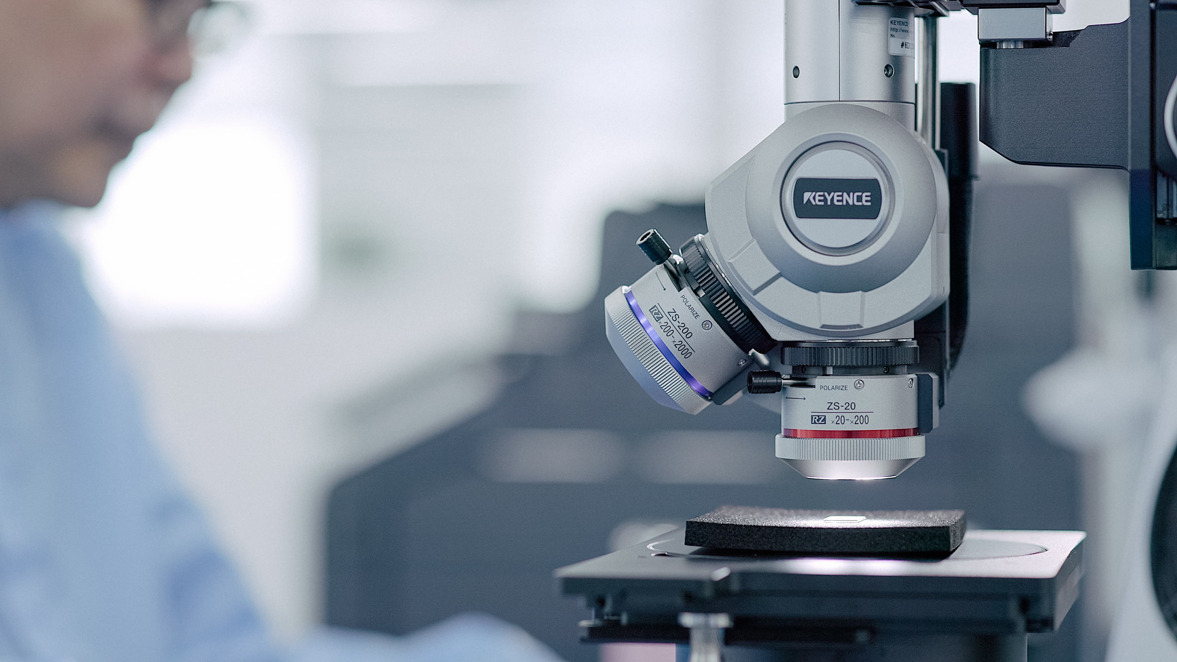 A Fusion Worldwide employee sitting in front of a microscope